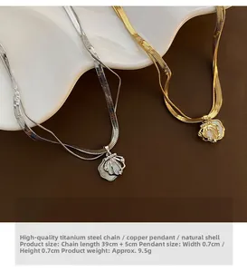 Detailed view of gold and silver shell pendant necklaces on a white decorative plate