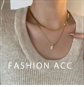 Close-up of a double-layer gold necklace featuring a zircon-encrusted mini flip-flop pendant