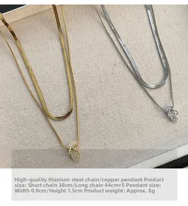 Close-up of gold and silver layered necklace with mini slipper pendant on linen