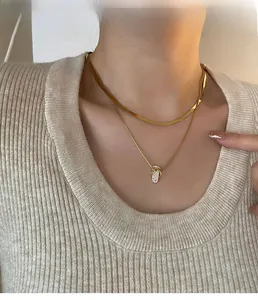 Close-up of gold layered necklace set with micro-paved flip-flop charm on a model