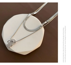 Detailed view of silver layered necklace featuring a micro-pave flip-flop pendant and snake chain