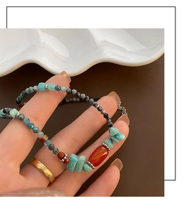 Macro di collana artigianale con perline di avventurina, agata rossa e chiusura in metallo