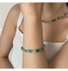 Gros plan sur un ensemble collier et bracelet en perles colorées avec pierres naturelles