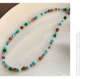 Gros plan d'un collier de perles en pierre naturelle colorée avec fermoir doré