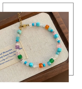 Détail d'un bracelet en perles de pierres naturelles colorées avec fermoir doré sur plateau