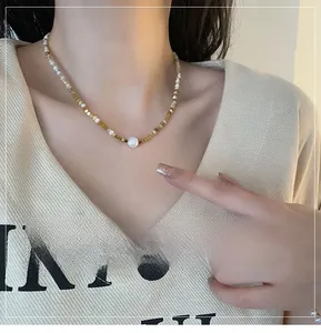 Detail of layered titanium necklace with natural freshwater pearls and golden beads