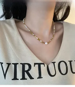 Detail of vintage beaded necklace with natural stones and a central freshwater pearl