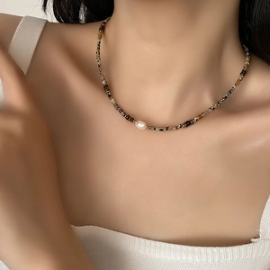 Baroque pearl necklace with tiger eye stone beads on a model with a white top