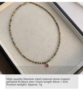 Detail view of natural stone beaded necklace with a red zircon pendant in 40cm length