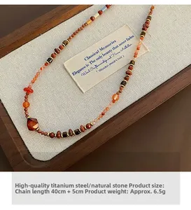 Detailed view of red agate and Czech beads necklace on vintage wooden jewelry box