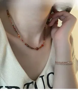Detail of red agate and freshwater pearl jewelry set worn by a model in warm light