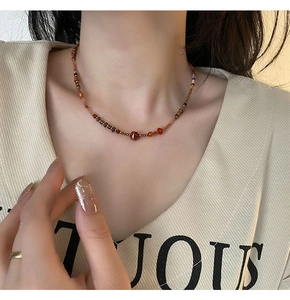 Detail shot of a red agate beaded necklace with Czech glass stones on a model