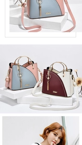Close-up of contrast color handbag with heart pearl tassel and gold ring handle