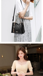 Detail of black leather handbag with white stitching, gold handle and heart tassel charm