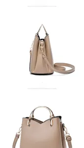 Detail view of khaki PU leather handbag with gold metal round handles and pearl pendant
