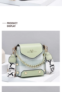Detail of light green PU leather and twill fabric bag with wide woven letter strap