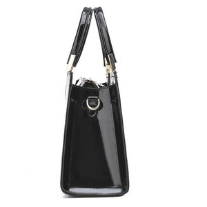 Elegant black patent leather handbag for women featuring gold hardware and a trapezoid shape