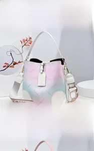 Détail du sac seau crème avec motifs floraux en dégradé et large bandoulière élégante