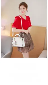 Detail of white sweet shoulder bag with cute cat charm and adjustable strap for women