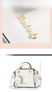 Detailed view of white textured handbag with gold logo and cat charm sizing dimensions