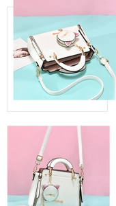 Close-up of white PU leather handbag featuring a cute cat coin purse charm and gold hardware
