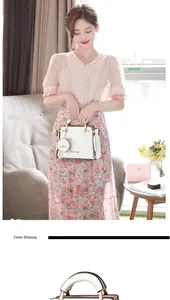 Close-up of stylish white handbag featuring gold-tone zippers and a cute cat head charm