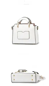 Detail showing the bottom of the white handbag with four protective gold metal studs