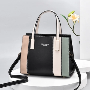 Sac à main chic avec design color-block et bandoulière sur un socle blanc épuré