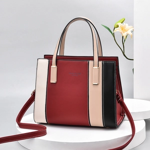 Sac à main tricolore en similicuir avec détails dorés et bandoulière sur socle blanc