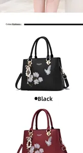 Details der Blumen- und Schmetterlingsstickerei auf schwarzen und burgunder Taschen