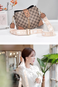 Details der karierten Leder-Beuteltasche mit Katzenschnalle und Blumen-Gurtband