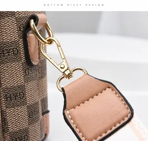 Nahaufnahme der vergoldeten Schnalle und Jacquard-Gewebe einer Luxus-Beuteltasche