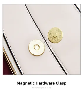 Detail of golden hardware magnetic clasp and zipper on a beige leather handbag