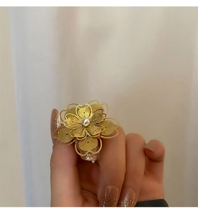 Vista dettagliata di un anello a fiore in oro con filigrana traforata e perla