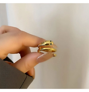 Detail of gold-plated snake ring with intricate snake head and dark zircon eyes