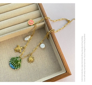 Detail of beach-style necklace featuring shell, turtle, and sun pendants with pearls