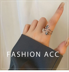 Macro detail of silver spiral heart ring featuring a layered wraparound design on hand
