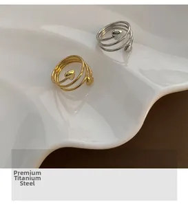 Detail of gold and silver spiral titanium steel rings with small heart motifs on a tray