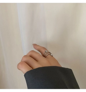 Close-up of a silver spiral heart-shaped open ring worn on a woman finger