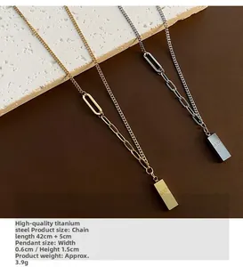 Vue macro de pendentifs rectangulaires en or et argent avec gravure GOLD sur acier titane