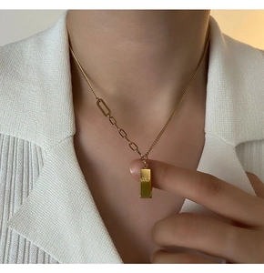 Détail du pendentif lingot d'or avec gravure GOLD sur chaîne asymétrique sur modèle