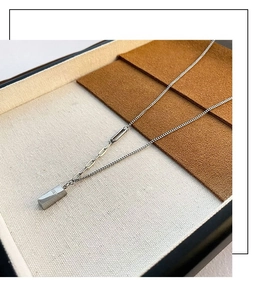 Détail du collier avec pendentif barre argentée gravé GOLD et maille de chaîne mixte