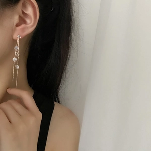 Elegant gold tassel drop earrings with sparkling zircon stones worn by a model