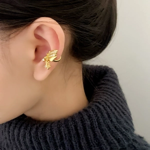 Elegant gold butterfly ear cuff with shimmering zircons worn on model's upper ear cartilage