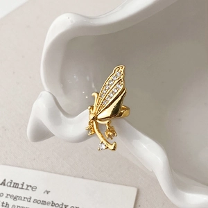 Macro shot of gold butterfly ear cuff featuring sparkling cubic zirconia on ceramic edge