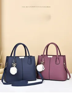 Close-up of retro litchi grain leather handbags with elegant metal hardware and pompom