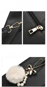 Detail of black lychee leather bag with gold hardware and plush ball pearl pendant