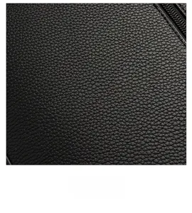 Close-up of black lychee grain texture with premium hardware magnetic clasp and zipper