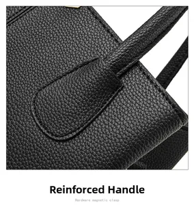 Close-up of reinforced handle and golden hardware on black lychee grain leather bag