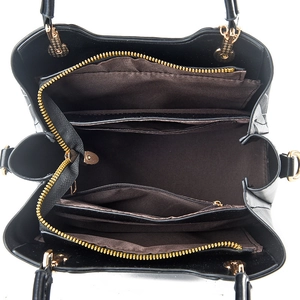 Top view of black handbag interior featuring multiple compartments and gold hardware